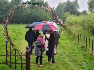 A group of guests walking towards the big top under umbrellas